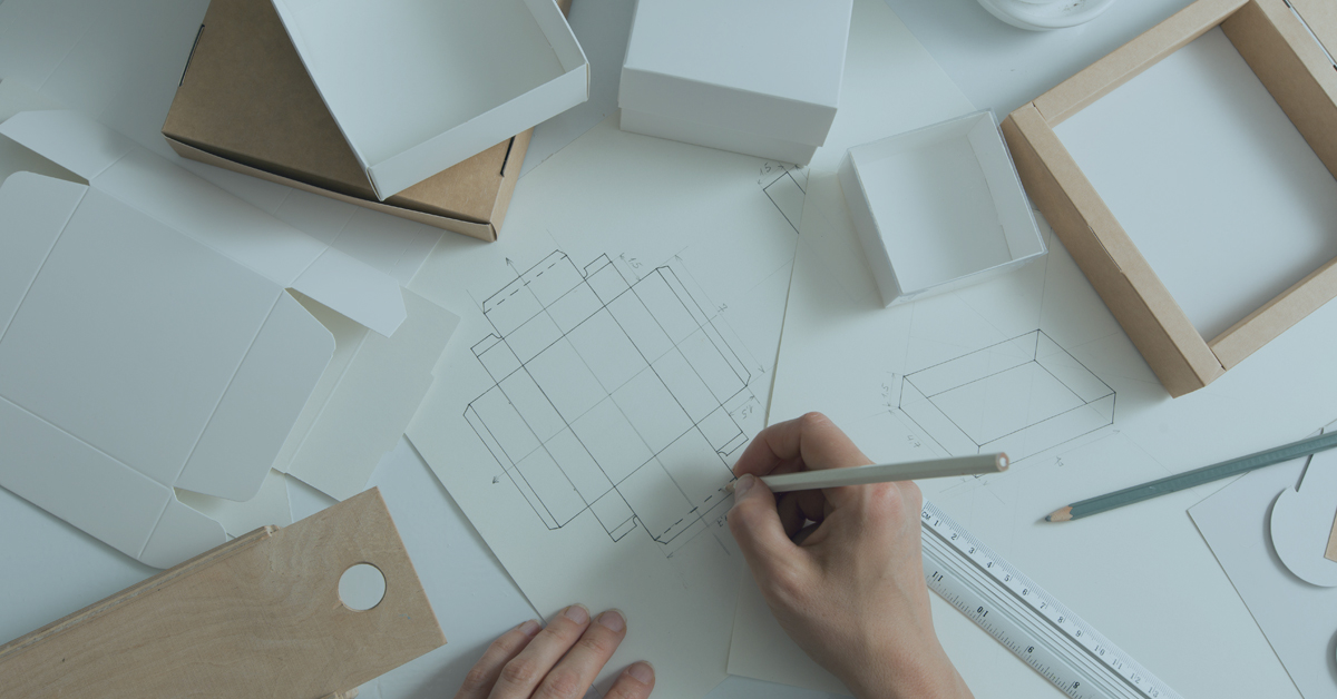 Designer draws a mockup for crafting eco cardboard box. Development a sketch of paper packaging.